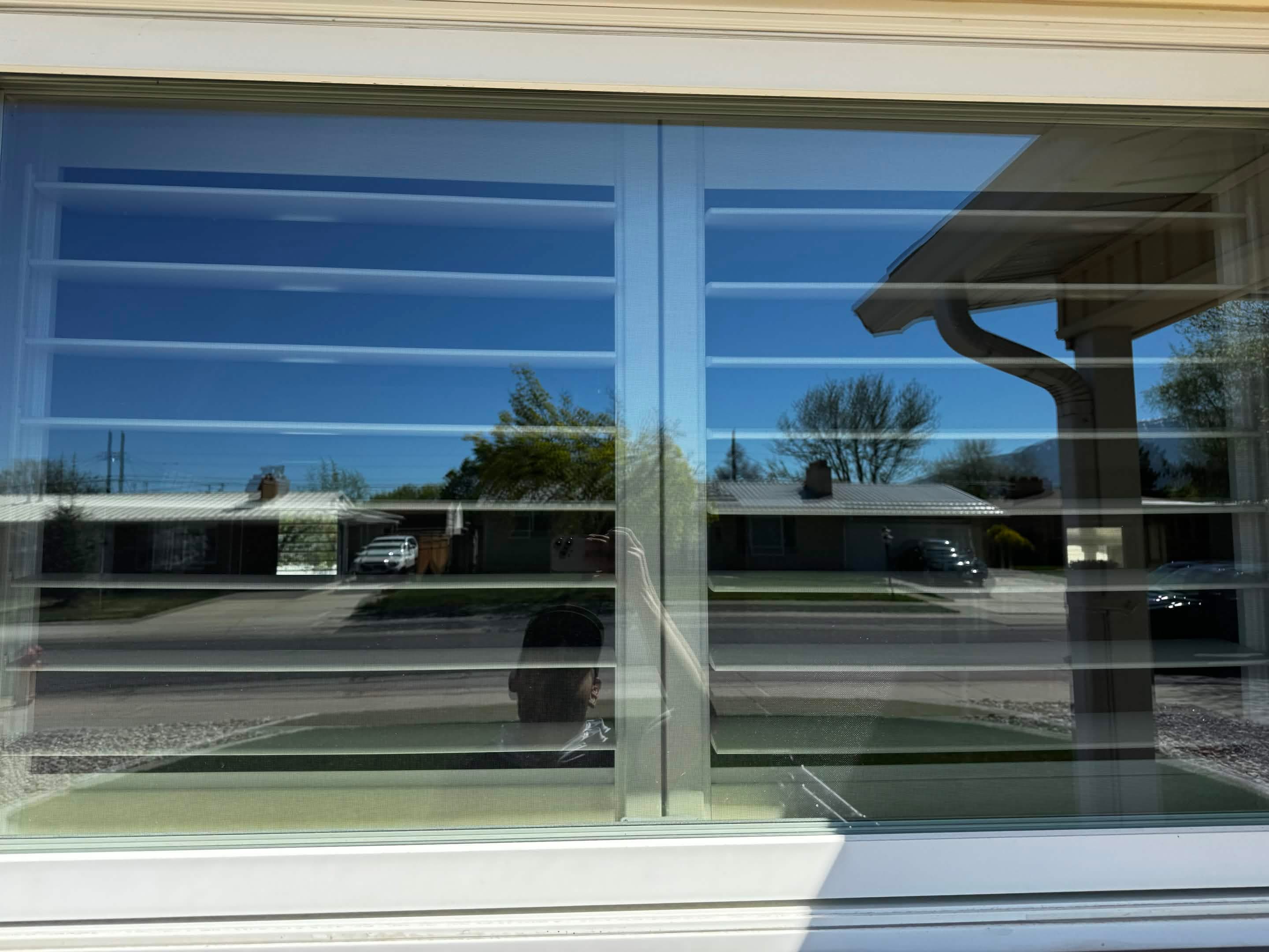 Streak-free exterior window glass reflecting a clear Utah County sky after cleaning.