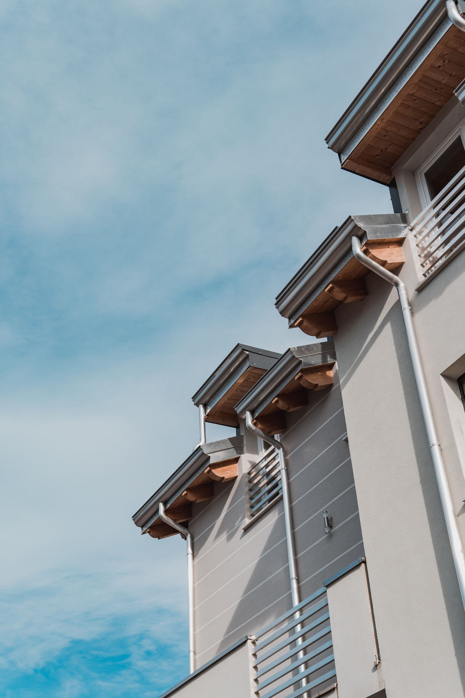 Clean gutters and downspouts along a home's eaves.