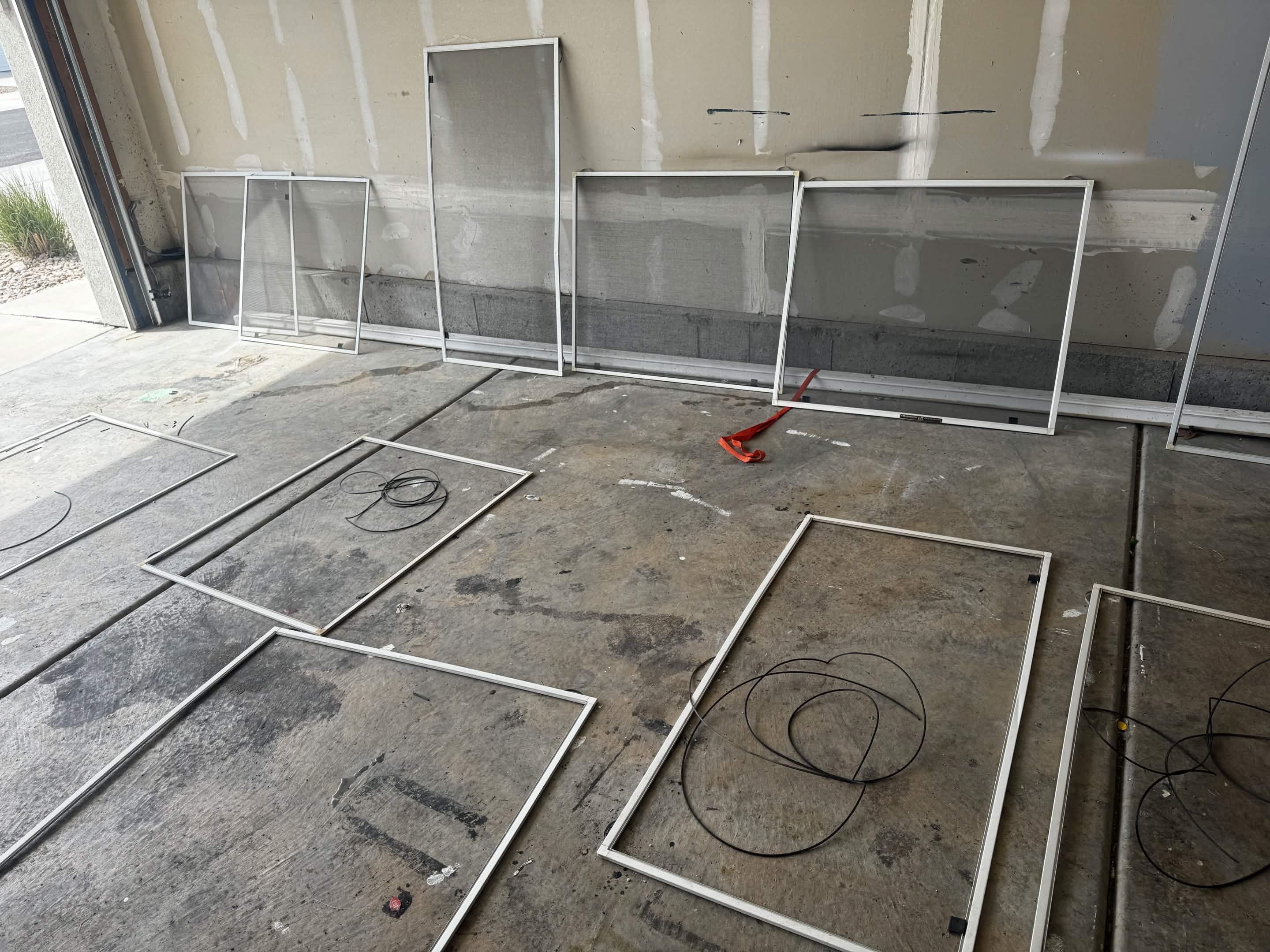 Window screen frames re-meshed and ready to refit during a screen repair job.